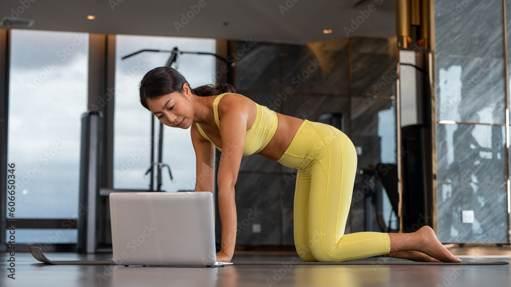 Social distance. A young woman stretching Yoga fitness instructor records a tutorial in fitness room on roof top workouts on camera.