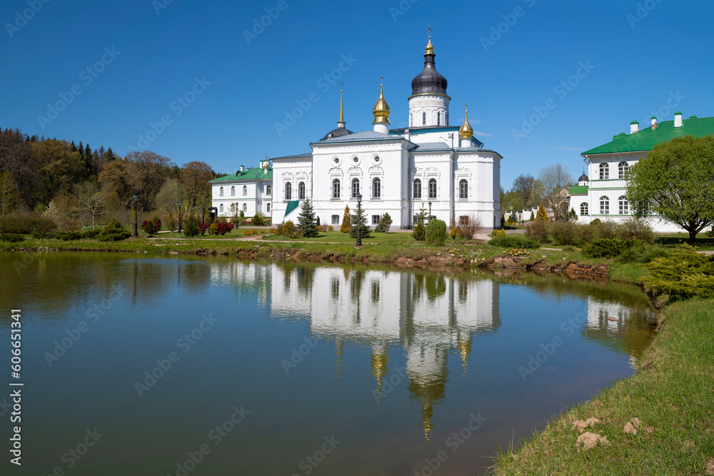 View of the Cathedral of the Three Saints (1574) with reflection in the Spaso-Eleazarovsky Monastery on a sunny May day. Pskov region, Russia
