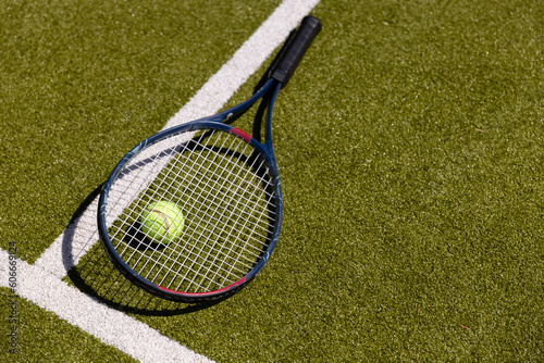 High angle view of tennis racket and ball by marking on grassy field at tennis court
