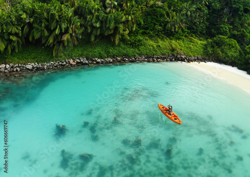 Drone's Eye View: Unrecognizable Woman Canoeing in a Tropical Exotic Destination. Aerial Perspective of an Unrecognizable Tourist Exploring Exotic Waters