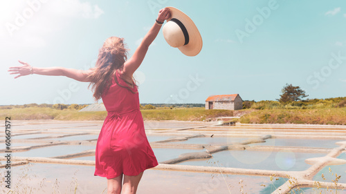Obraz na plátně Happy woman with red dress enjoying salt marsh in Guerande,  Saline- Loire Atlan