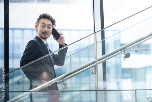 綺麗なオフィスで電話をするスーツ姿の中年ビジネスマン © kapinon