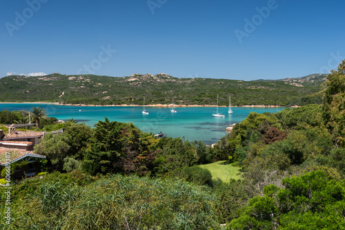 The panorama of Porto Cervo, a luxurious Italian summer resort in Costa Smeralda, Sardinia. Villa, bay with yachts, vibrant green garden.
