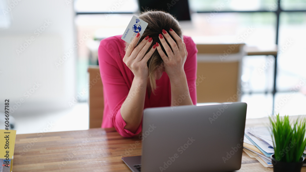 Αυτοκόλλητο Upset woman sitting at laptop with credit plastic card and holding his head