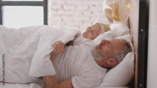 The middle age couple sleeping in the bed. slow motion