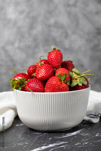 Strawberry in bowl. Organic farm products. Fresh strawberries on dark background