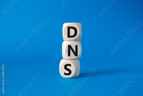 DNS -Domain Name Server - Consumer Price Index symbol. Concept word DNS on wooden cubes. Beautiful blue background. Business and DNS concept. Copy space.