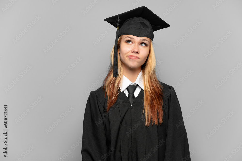 Young university graduate girl over isolated background and looking up Young university graduate girl over isolated background and looking up