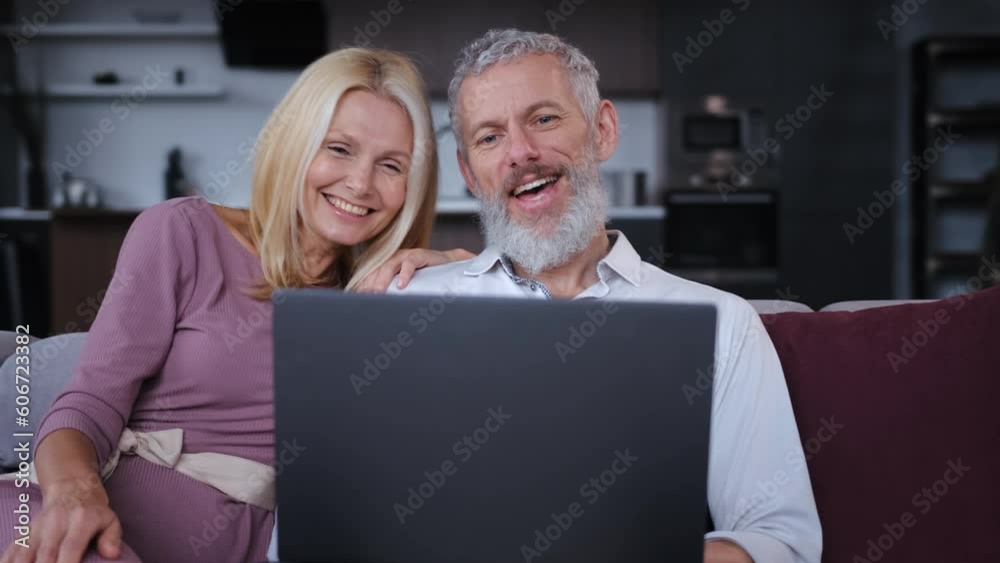 The happy middle age couple chatting on laptop. slow motion The happy middle age couple chatting on laptop. slow motion