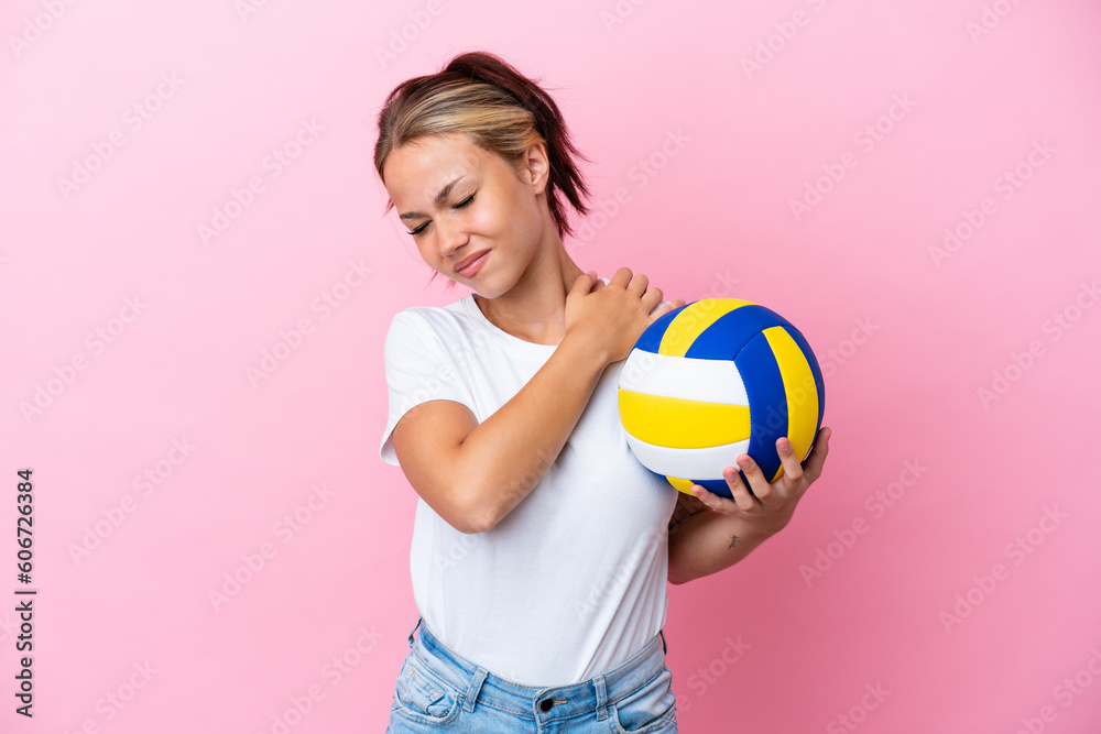 Young Russian woman playing volleyball isolated on pink background suffering from pain in shoulder for having made an effort
