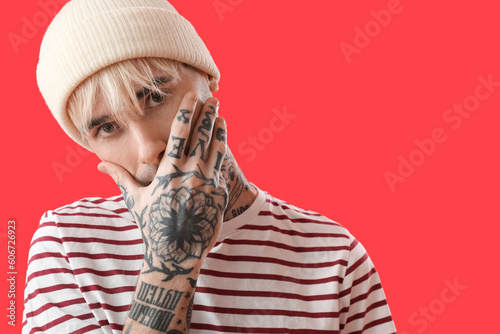 Tattooed young man in hat o...