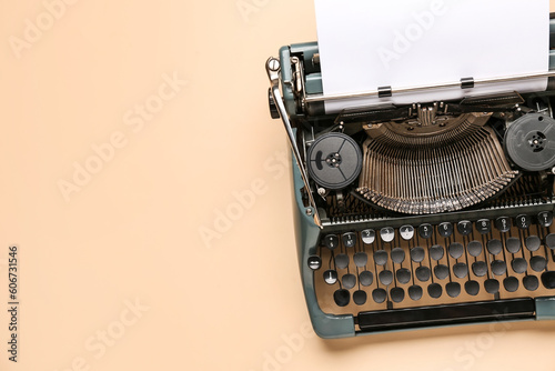 Vintage typewriter with blank paper sheet on beige background