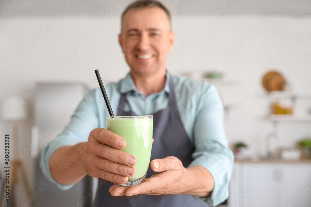 Mature man with glass of fresh vegetable smoothie in kitchen, closeup Mature man with glass of fresh vegetable smoothie in kitchen, closeup