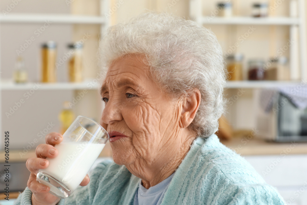 Senior woman drinking milk in kitchen, closeup Senior woman drinking milk in kitchen, closeup
