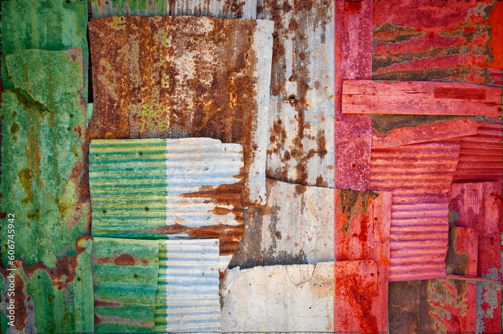 Flag of Italy on rusty corrugated iron sheets forming a wall or a fence