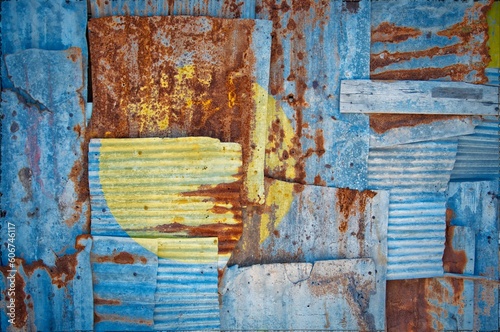 Shot of the flag of Palau painted on rusty overlapping corrugated iron sheets © Tonygers/Wirestock Creators