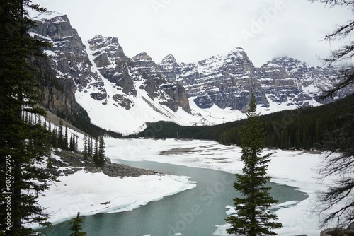 Forest and rocky, snow-capped mountains reflected in Lake Moraine in Banff National Park Canada