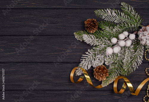 banner greeting card with Christmas tree decor with cones ornament with a golden serpentine for the New Year holiday on a wooden board