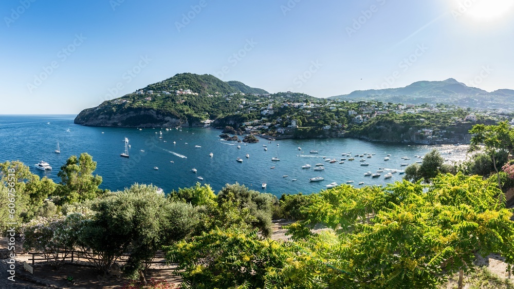 Landscape view of green hills around the sea with boats in Sicily, Italy