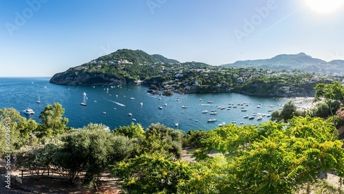 Landscape view of green hills around the sea with boats in Sicily, Italy