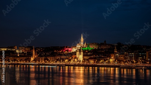 View of the illuminated skyline of Budapest, Hungary at the night reflected in waters © Razvan Mirodotescu/Wirestock Creators