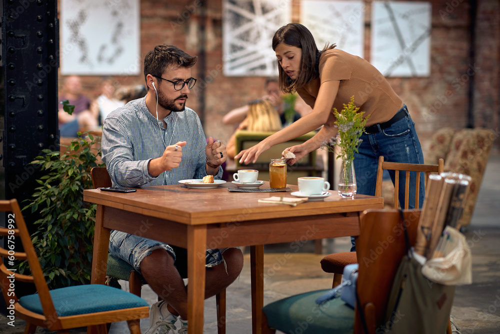 Young students in cafeteria, enjoying coffee. Man and woman together. Young students in cafeteria, enjoying coffee. Man and woman together.