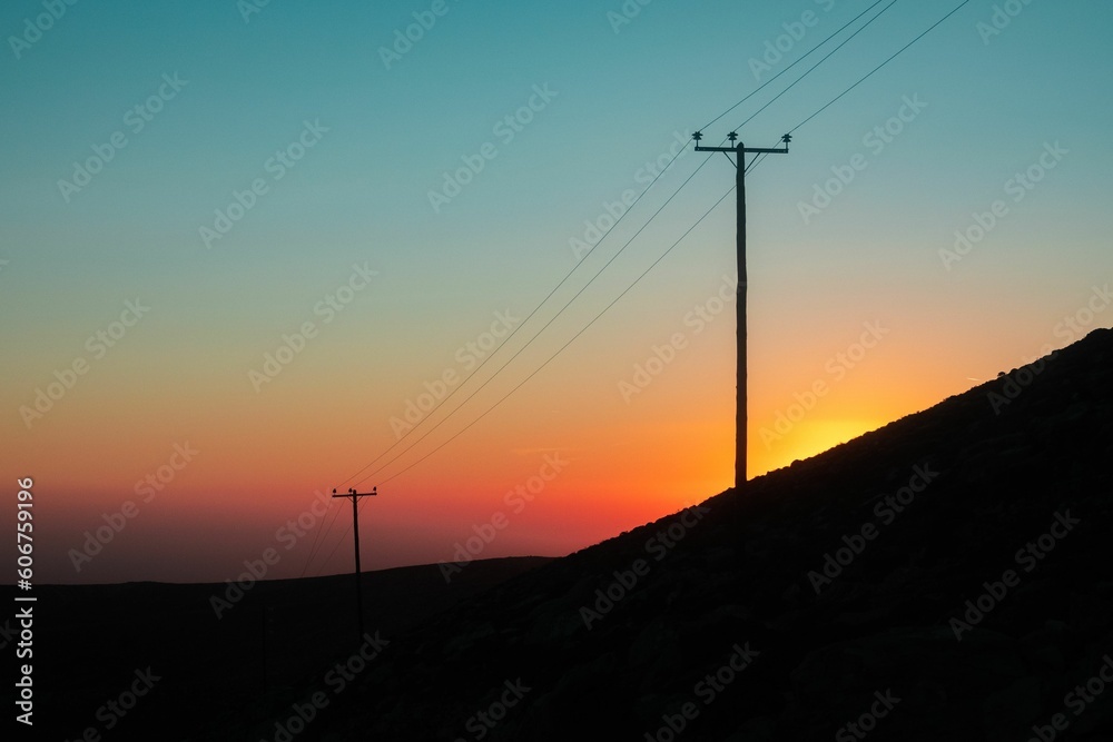 Scenic sunset with electrical poles and colored sky