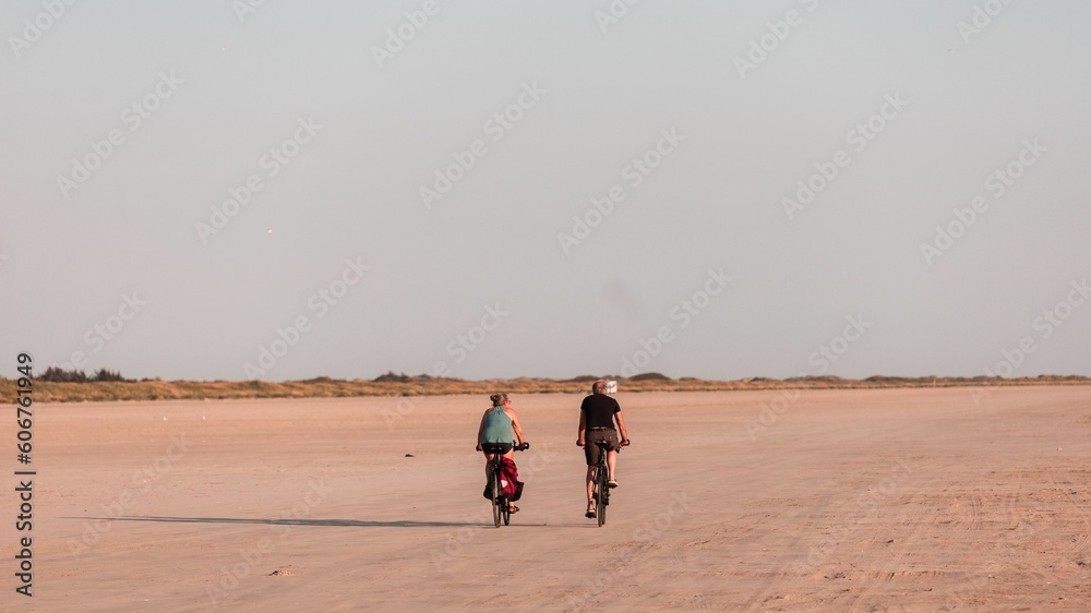 Φωτογραφία Women riding bicycles on the sandy shore of Fano Island on a sunny day