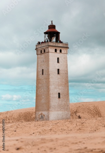 Vertical shot of the Rubjerg Knude lighthouse on sand dunes in Lokken, Denmark © Juri Völker/Wirestock Creators