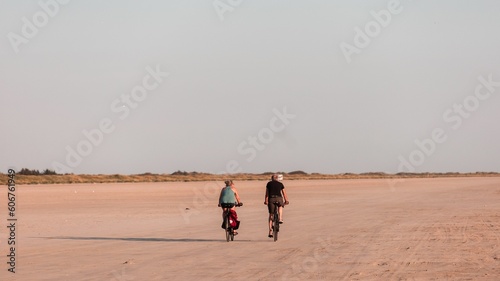 Women riding bicycles on the sandy shore of Fano Island on a sunny day. Denmark photo