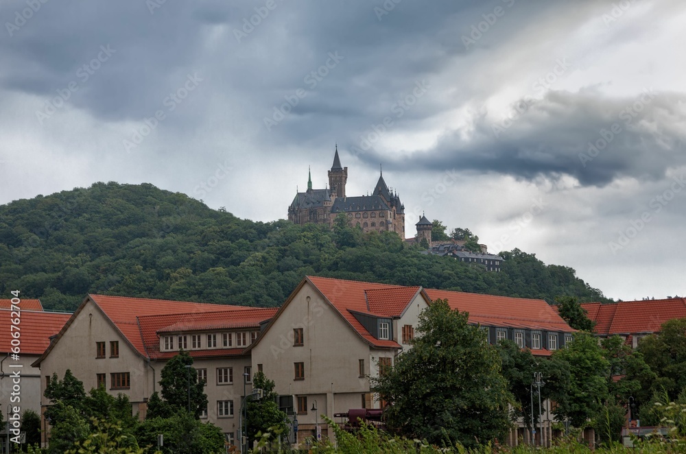 Antique castle Wernigerode in Germany surrounded by mountains covered by trees
