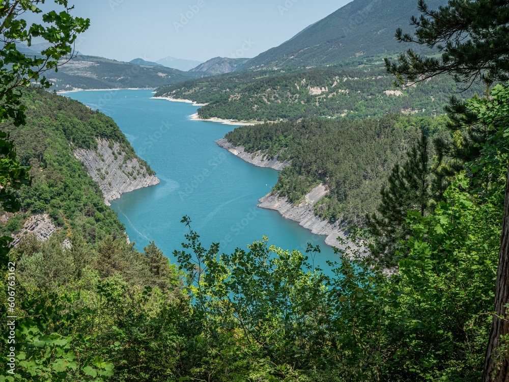 Aerial view of lake surrounded dense trees in Isere