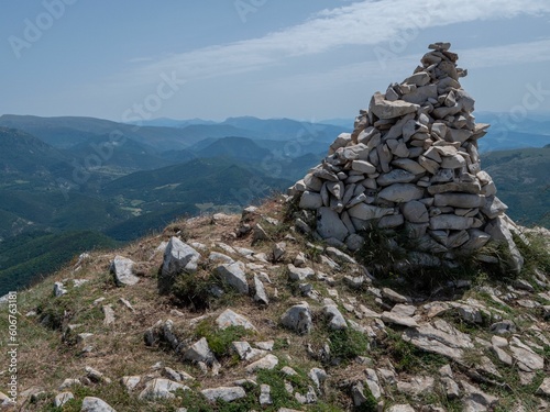 Rock pyramid on top of the Montagne de la Lance with mountains in the background against a blue sky © Tdal/Wirestock Creators