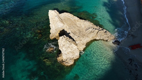Aerial drone shot of a blue sea with a huge rock formation in Monterosso al Mare, La Spezia, Italy