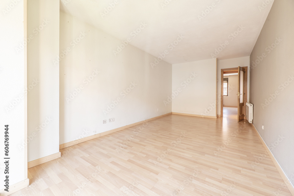 A spacious empty living room with a wooden floor A spacious empty living room with a wooden floor