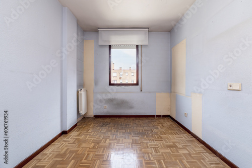 An empty room with a varnished oak parquet floor with a red aluminum