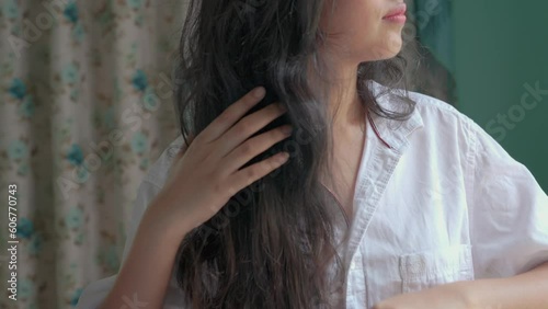 woman combs her hair.  hair stuck in the comb. hairfall photo