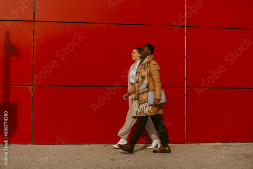 Multiracial business outdoors. Black and Caucasian business people walking one next to each other