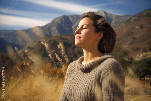 Group portrait photography of a woman in her 40s practicing mindfulness sophrology relaxation & stress-reduction wearing a cozy sweater against a mountain landscape background