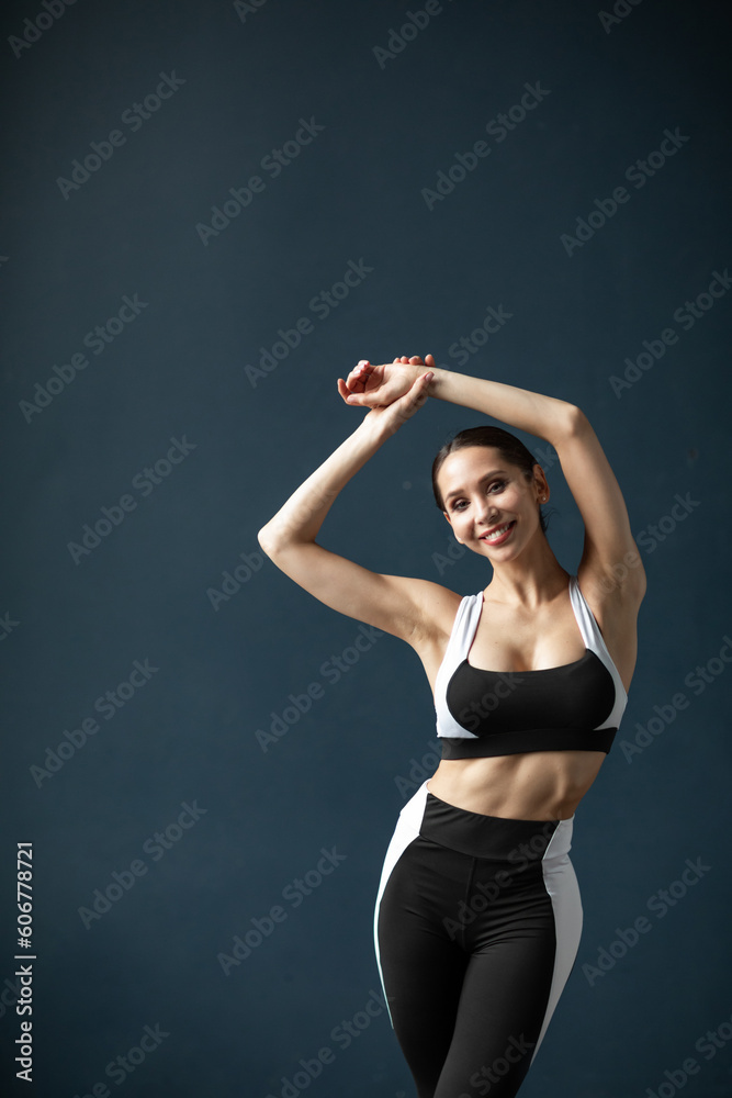 Portrait of beautiful fitness sexy woman indoors on wall background.