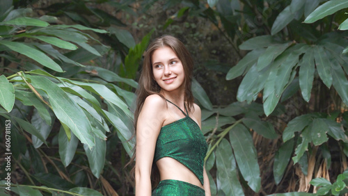 young woman in green dress at tropical leaves background