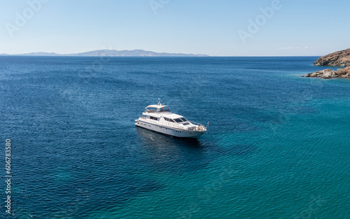 Greece summer destination Cyclades island. Moored luxury yacht in Aegean sea water background.