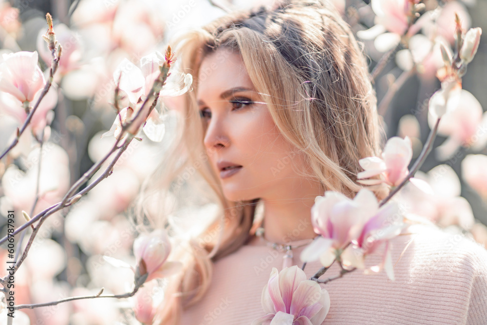 Portrait of a beautiful happy middle aged woman enjoying the smell in a blooming spring garden. Beautiful magnolia bushes, large flowers. Portrait of a beautiful happy middle aged woman enjoying the smell in a blooming spring garden. Beautiful magnolia bushes, large flowers.