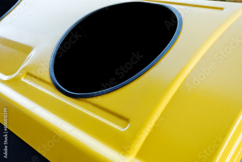 A yellow plastic recycling garbage can is a container specifically designed to collect and separate yellow plastic waste for recycling. photo