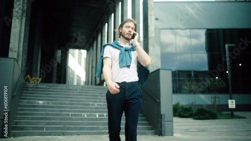 Wallpaper Mural Happy successful male entrepreneur talking mobile phone walking along business district. Successful businessman going to work Torontodigital.ca