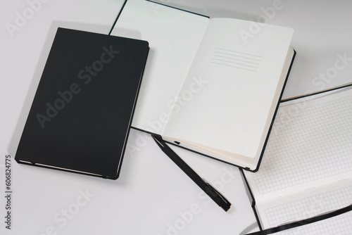 Mockup of a black diary in a leather cover with a pen and a pencil on the table without a logo. A5 notebook