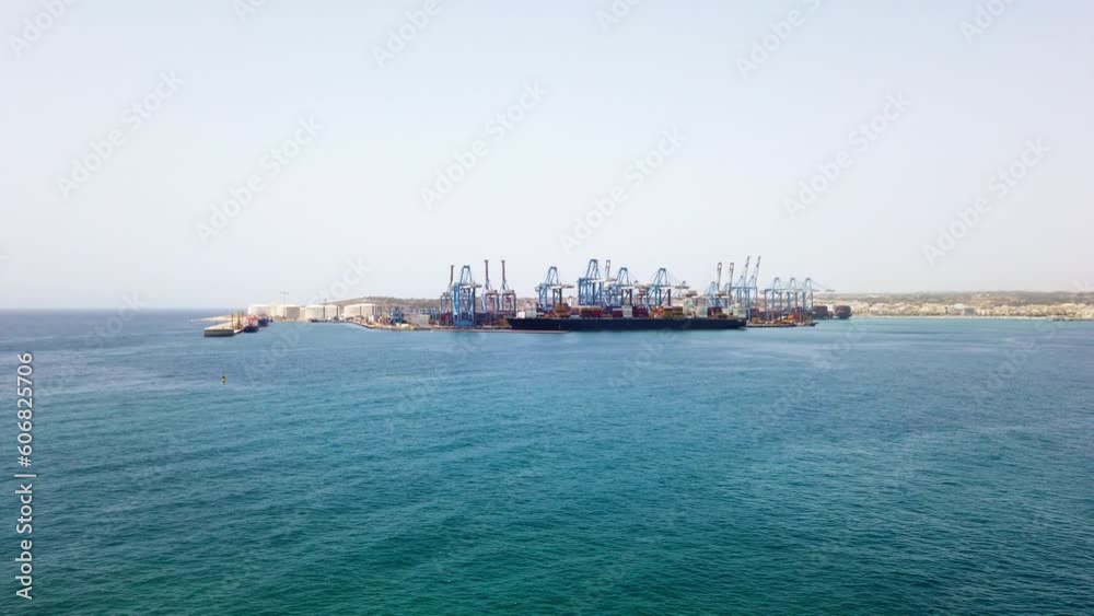 Marsaxlokk, Malta - 21 June 2021: View on Freeport Centre in Malta, Marsaxlokk town and Il-Brolli town in the background. Marsaxlokk, Malta - 21 June 2021: View on Freeport Centre in Malta, Marsaxlokk town and Il-Brolli town in the background.