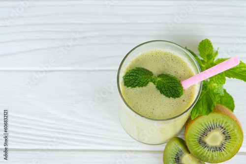 Kiwi yogurt fruit juice smoothie green colorful fruit juice milkshake blend beverage healthy high protein the taste yummy In glass drink episode morning on white wood background from the top view.