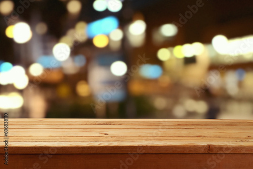 Empty wooden table over abstract blurred bokeh night lights background. Mock up for design and product display.