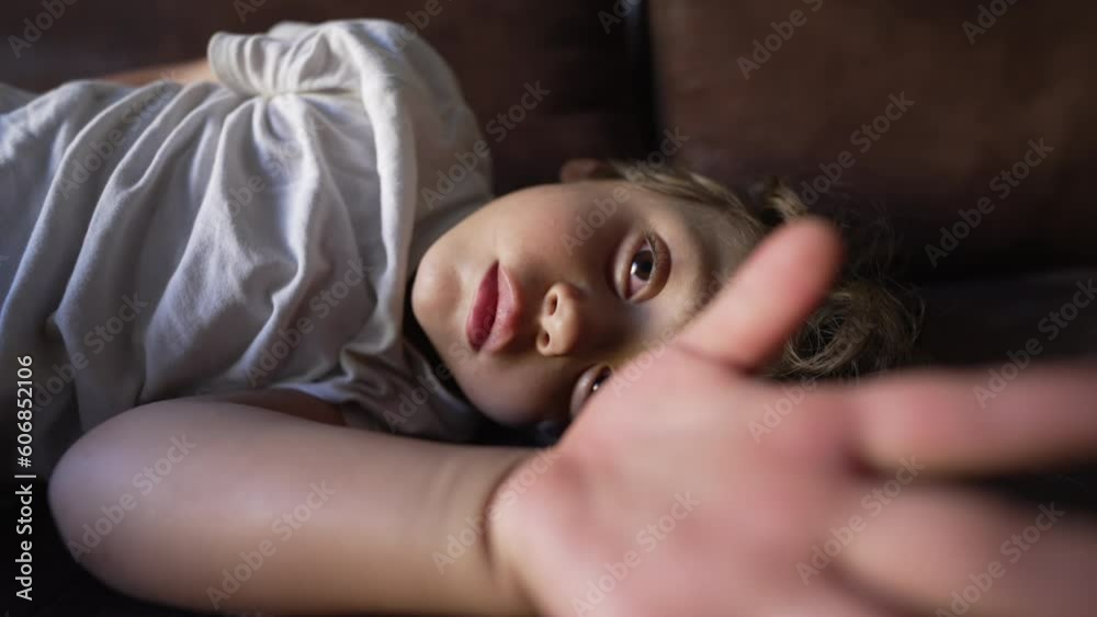 One tired little boy waking up from nap. Sleeping child wakes up from slumber. Small kid opening eyes lying on couch One tired little boy waking up from nap. Sleeping child wakes up from slumber. Small kid opening eyes lying on couch